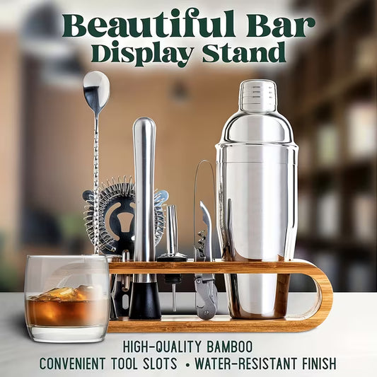 Stainless steel bartender set in a bamboo stand next to a glass of whiskey on a bar