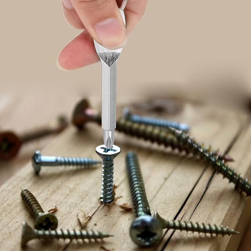 Hand holding a mini keychain screwdriver against a screw, with loose screws on a wooden surface